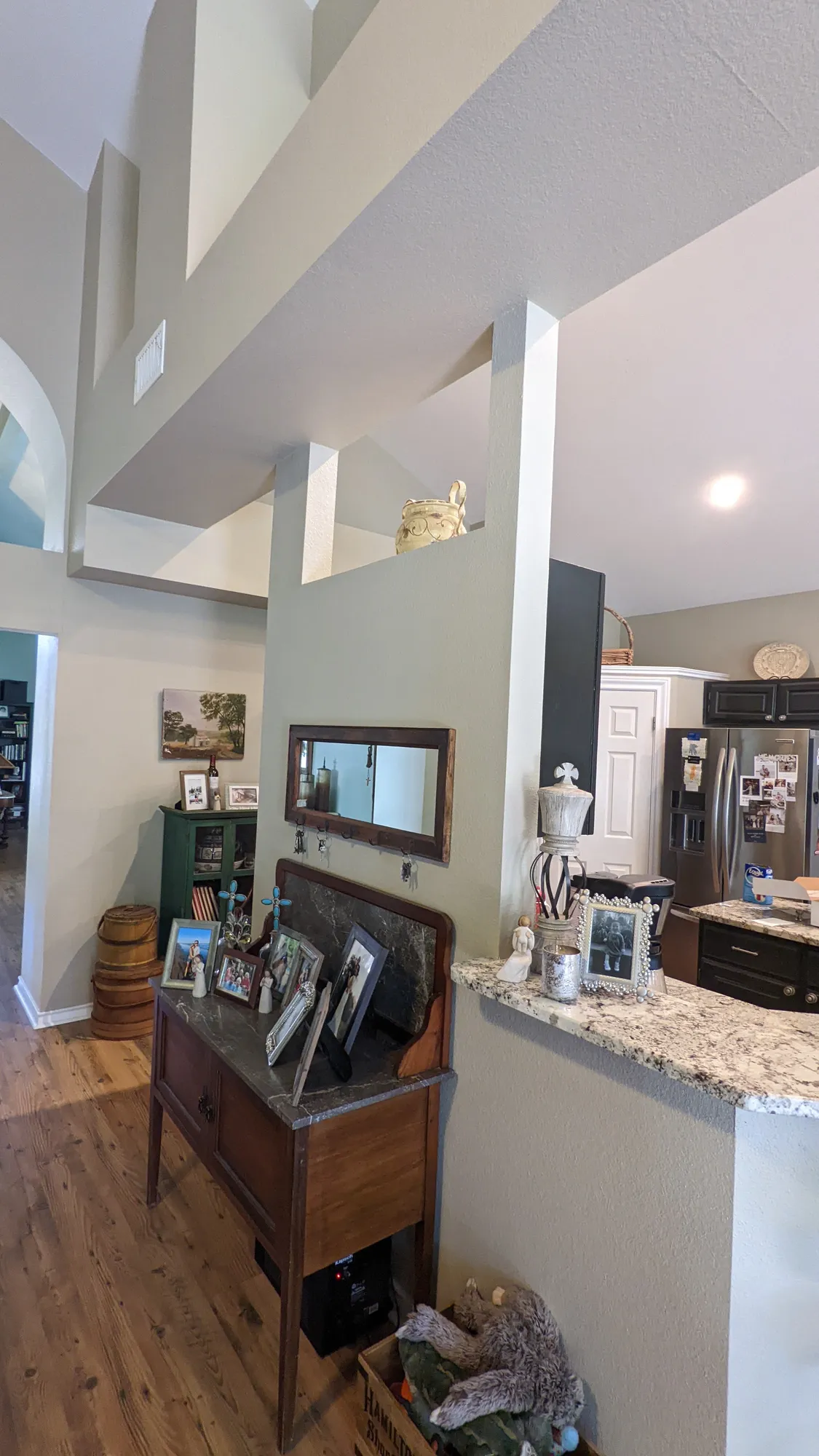 Before: hallway into the kitchen past a half wall with a dark wood console